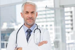 male doctor wearing stethoscope standing in office